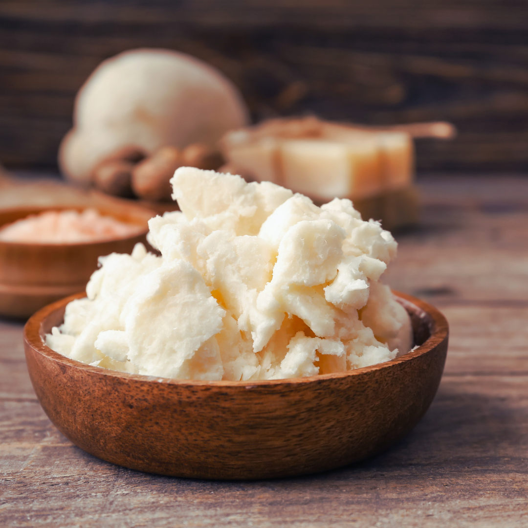 Wooden bowl containing white shea butter